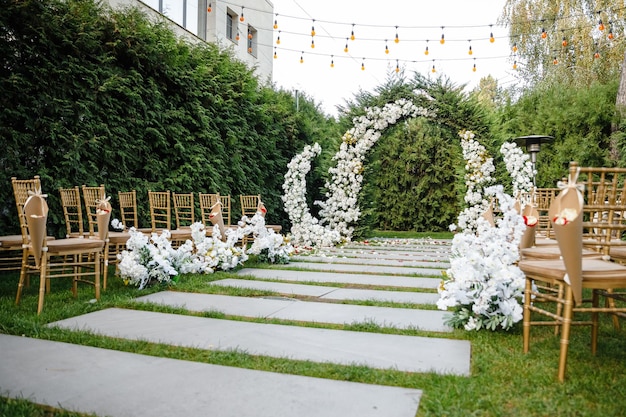 Belle décoration de mariageArche décorée de fleurs blanches et de chaises en boisBelle décoration de mariage