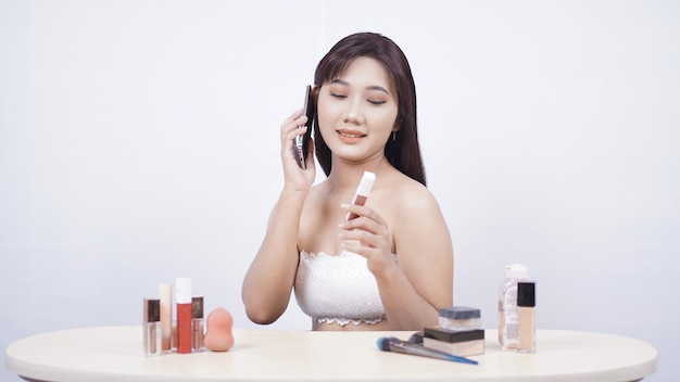 Belle discussion de maquillage asiatique au téléphone isolé sur fond blanc