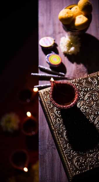 Photo belle diwali diya avec des pétards et du pera sucré, mise au point sélective