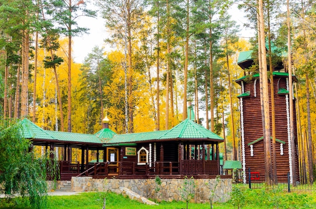 Belle église en bois au milieu d'une forêt d'automne avec un pont en bois