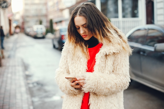 belle et élégante fille en vêtements de mode marchent dans la ville de printemps