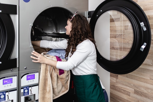 Belle employée travaillant à la laverie automatique.