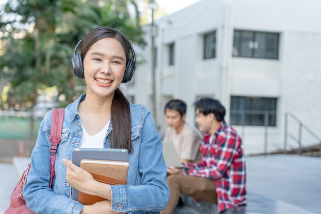 Belle étudiante asiatique avec sac à dos et livres en plein air Sourire fille heureuse portant beaucoup de livres sur le campus universitaire Portrait d'une femme sur l'école d'étude internationale Asia University Education