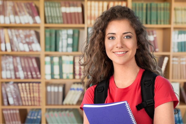 Belle étudiante en bibliothèque avec ordinateur portable