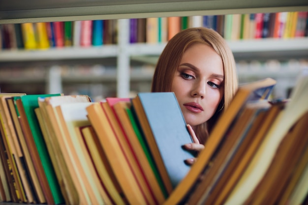 Belle étudiante dans la bibliothèque universitaire