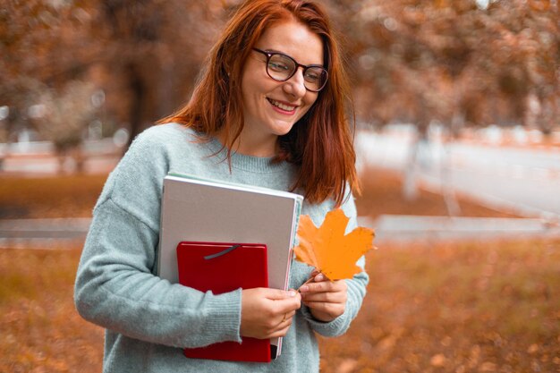 Belle étudiante avec des livres dans un parc