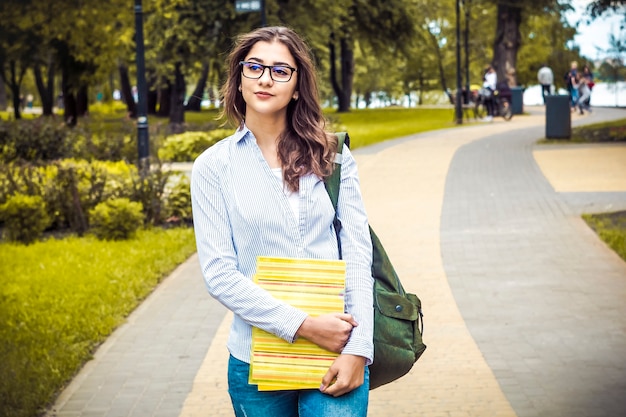 Une belle étudiante à lunettes, avec des livres.