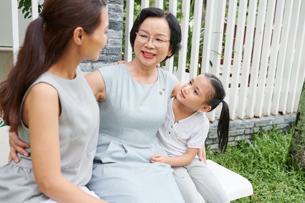 Belle famille asiatique assise à l'extérieur