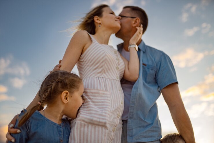 Photo belle famille au coucher du soleil sur la plage