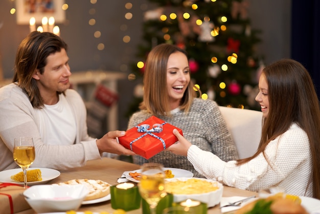 Belle famille avec des cadeaux partageant des cadeaux pendant le dîner de Noël