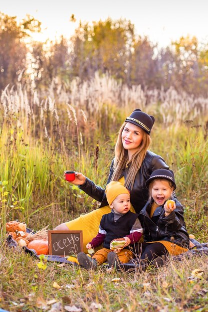 Belle famille avec un chien golden retriever lors d'une promenade dans la nature ensoleillée d'automne