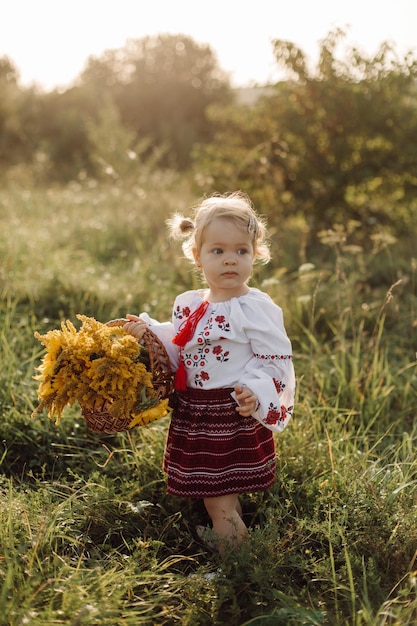 Belle famille avec enfant en costume ethnique traditionnel dans un parc de campagne