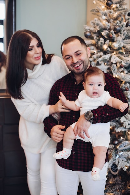 Belle famille avec enfant profitant de l'atmosphère de Noël ensemble