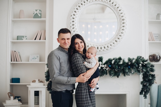 Belle famille avec enfant profitant de l'atmosphère de Noël ensemble