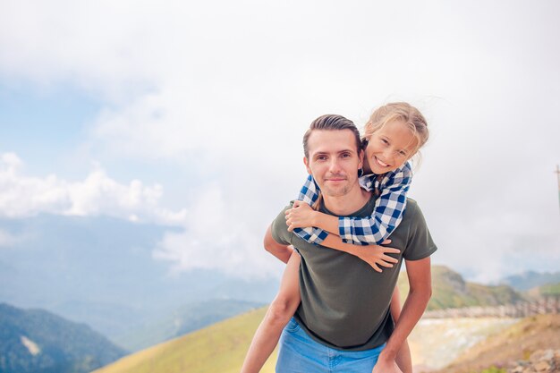 Belle famille heureuse dans les montagnes en arrière-plan de brouillard