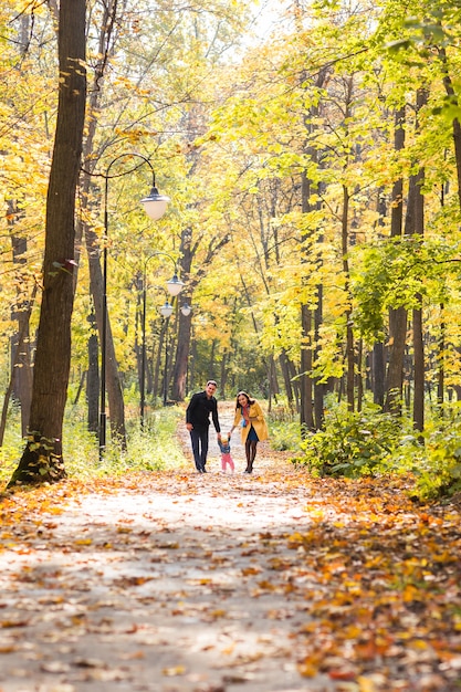 Belle famille marchant dans la forêt d'automne