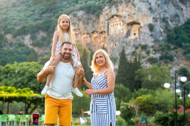 Une belle famille se dresse sur le fond d'une montagne dans la ville de Dalyan.Les gens près des tombes lyciennes en Turquie