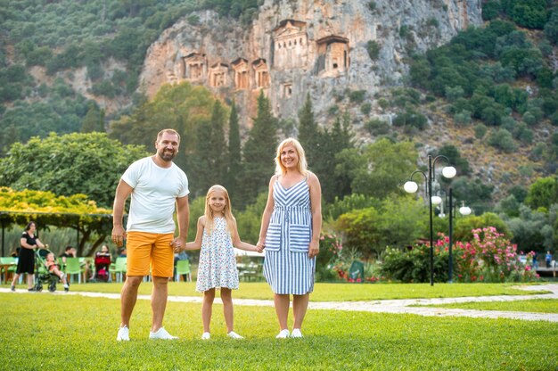 Photo une belle famille se dresse à la surface d'une montagne dans la ville de dalyan. des gens près des tombes lyciennes en turquie.