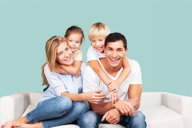 Belle famille souriante assise au canapé à