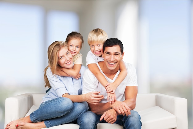 Belle famille souriante assise sur un canapé à la maison