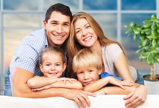 Belle famille souriante assise sur un canapé