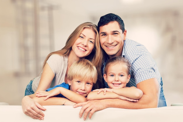 Belle famille souriante dans la chambre sur canapé