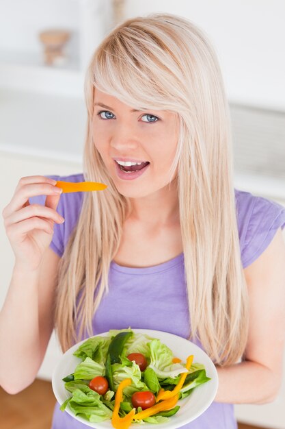 Belle femelle souriante manger sa salade