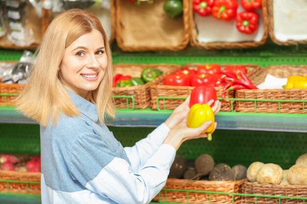 Belle femme achetant des légumes au marché