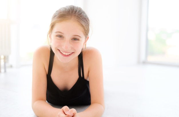 Belle femme adolescente allongée sur un sol dans une pièce lumineuse