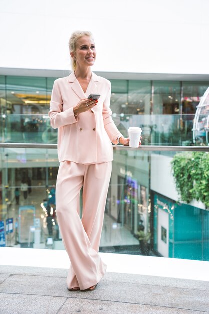 Belle femme d'affaires à l'aéroport partant pour un voyage de travail. Utiliser un smartphone pour passer un appel téléphonique