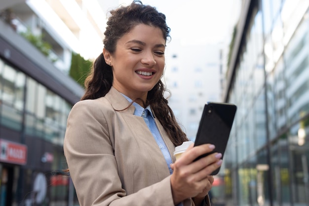 Belle femme d'affaires à l'aide de téléphone à l'extérieur