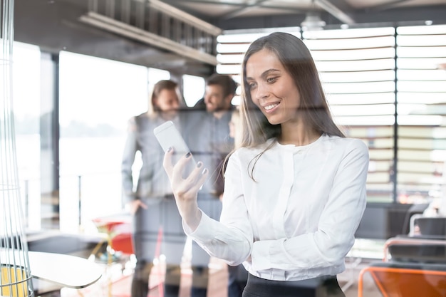 Belle femme d&#39;affaires à l&#39;aide d&#39;un téléphone portable dans son bureau