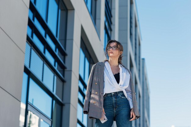 Une belle femme d'affaires dans un costume avec un document marchant à la réunion près d'un bureau moderne