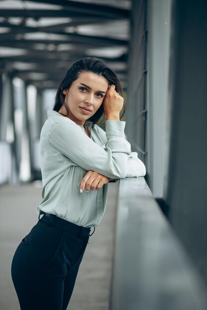 Belle femme d'affaires debout près du pont à côté du centre d'affaires