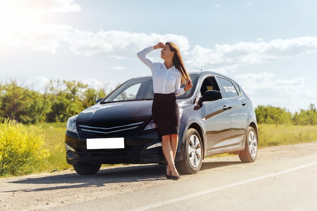 Belle femme d'affaires debout près de sa voiture