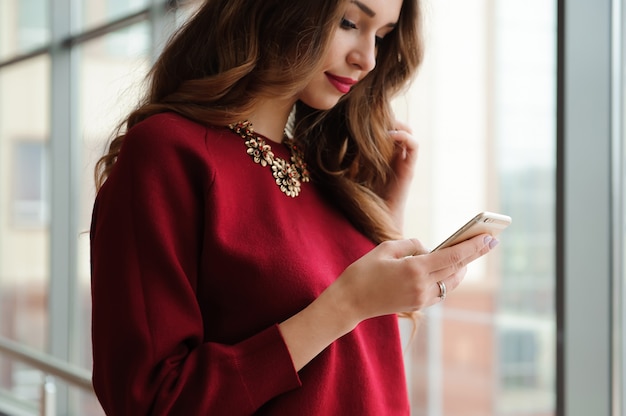 Belle femme d'affaires écrit des sms sur un téléphone mobile.