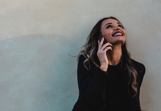 Photo belle femme d'affaires à l'extérieur avec téléphone portable. jeune brune au téléphone