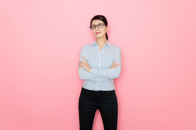 belle femme d'affaires face à la caméra croise la main du bras isolée sur fond rose