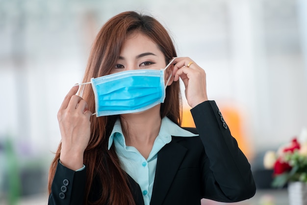 Belle femme d'affaires portant un masque après la propagation du virus covid-19 pour prévenir la propagation des germes et des bactéries et éviter les maladies coronariennes.