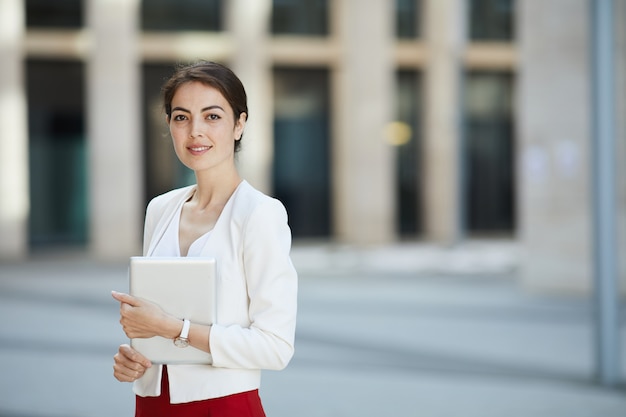 Belle femme d'affaires posant à l'extérieur