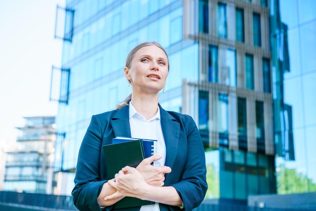 Belle femme d'affaires réussie debout contre des bâtiments en toile de fond écrit