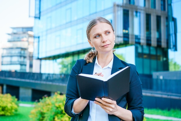 Belle femme d'affaires réussie debout contre des bâtiments en toile de fond écrit