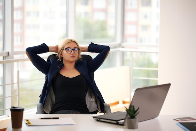 Belle femme d'affaires rêvant alors qu'elle travaillait à l'ordinateur à son bureau