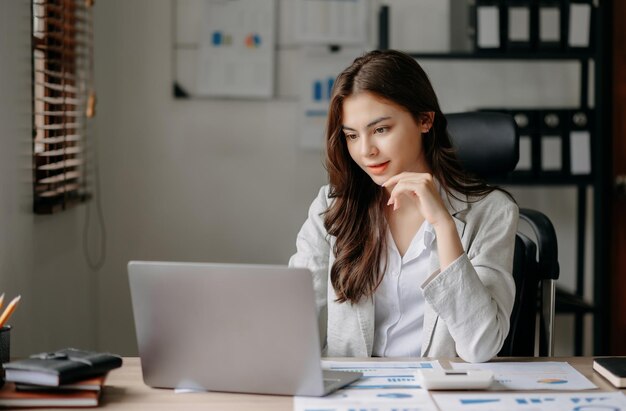 Belle femme d'affaires tapant un ordinateur portable et une tablette Placé à la table au bureau