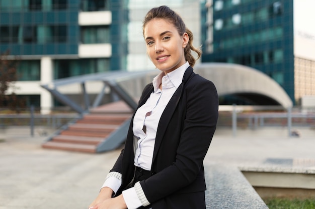 Belle femme d'affaires tenant un ordinateur portable dans le quartier des affaires