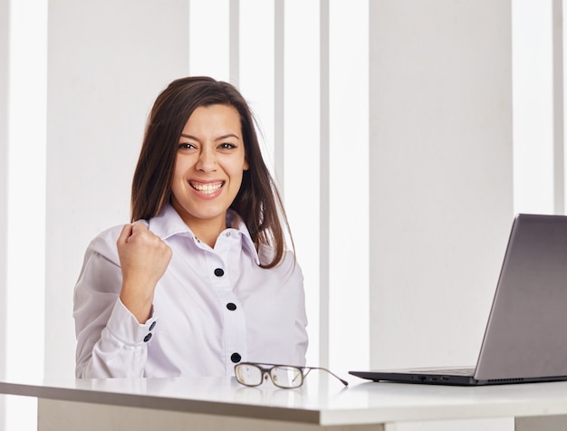 Belle femme d'affaires travaillant sur un ordinateur portable. Elle est heureuse.