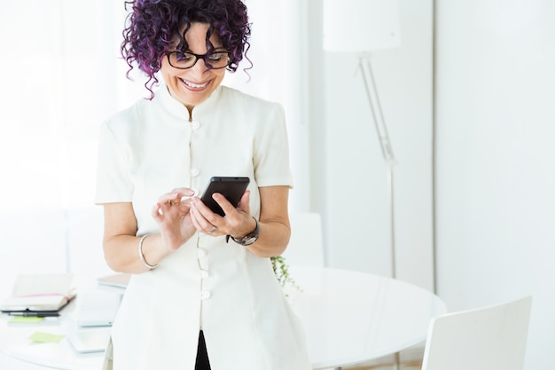 Belle femme d&#39;affaires travaillant avec son téléphone portable au bureau.