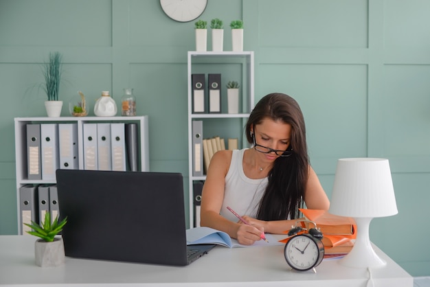 belle femme d'affaires travaille au bureau sur un ordinateur portable pigiste au travail l'enseignant enseigne