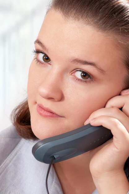 Une belle femme d'affaires travaille avec un téléphone dans son bureau.