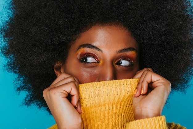 Belle femme africaine couvrant sa bouche avec le pull